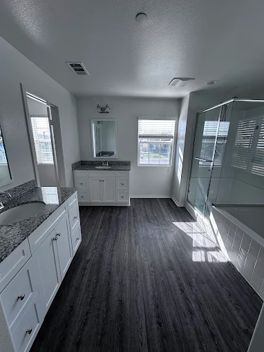 A sparkling-clean modern bathroom with a glass shower and vanity after a deep clean