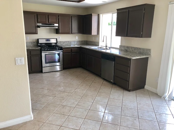 A freshly cleaned kitchen with granite countertops and wiped cabinets