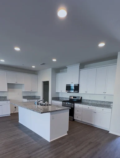 A modern kitchen deep cleaned top to bottom, with a granite island and spotless stainless appliances
