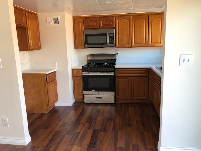 Deep-cleaned kitchen with wood cabinets and a spotless stainless steel stove