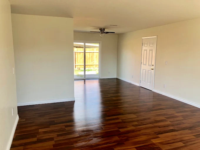 Move-out clean: an empty living room with gleaming dark hardwood floors